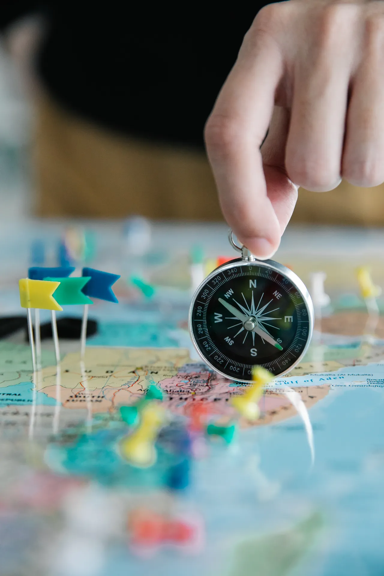 Operational maps — a hand holding a compass above a map with location pins